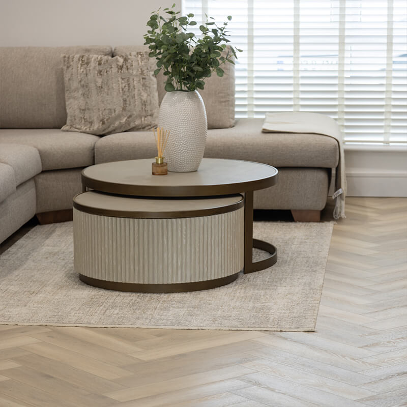 Modern SPC vinyl flooring in a contemporary living room with a beige sofa and round coffee tables